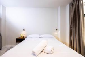 une chambre avec un grand lit blanc avec deux oreillers dans l'établissement Apartamentos Turísticos Insulae , by CartagenaSpain, à Carthagène