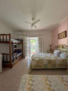 Un dormitorio con dos camas y un ventilador de techo. en Mama House, en Ubatuba