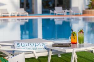 a table with two drinks on it next to a pool at ESTIMAR Calpe Suitopia in Calpe