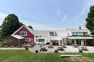 a large red barn with picnic tables in front of it at Craftsbury Farmhouse in Craftsbury