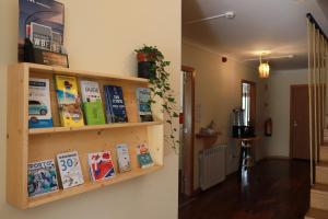 a book shelf on a wall with books at Oportocean Hostel in Matosinhos