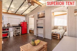 eine Küche mit einem roten Kühlschrank und einem Tisch mit Obst darauf. in der Unterkunft Glamping Tents | Losinj | Camp Čikat in Mali Lošinj