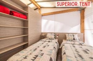 2 Betten in einem Zimmer mit Regalen in der Unterkunft Glamping Tents | Losinj | Camp Čikat in Mali Lošinj