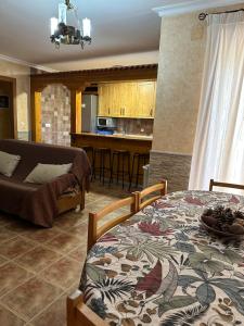 a kitchen and a living room with a table and a couch at Casas Rurales Cerro Lobo in Yeste