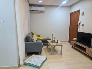 un salon avec un canapé et une télévision dans l'établissement شقق الفيروز الفندقية الدمام حي النور دخـول ذاتي, à Dammam