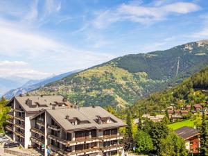 an apartment building with mountains in the background at Apartment Valaisia 35A by Interhome in Nendaz