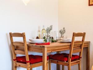 a wooden table with two chairs and a table with a bottle of wine at Apartment Valaisia 35A by Interhome in Nendaz +21 photos