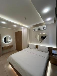 Un dormitorio con una gran cama blanca en una habitación. en 7 Days Hotel, en Umm Uthainah