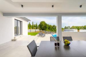 a dining room with a table and chairs on a patio at Villa Kama by IstriaLux in Juršići