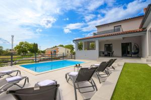 a patio with chairs and a swimming pool at Villa Kama by IstriaLux in Juršići