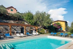 サンタ・マルゲリータ・リグレにあるCasa di Pietraの椅子と家のあるプール