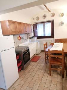 a kitchen with a white refrigerator and a table with a dining room at La casa nel borgo in Orsogna