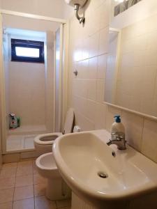 a white bathroom with a sink and a toilet at La casa nel borgo in Orsogna