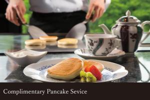 a table with a plate with a sandwich and a cup of tea at Yamanaka Onsen Kissho Yamanaka in Kaga