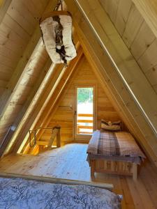a room in a log cabin with a bed and a window at Gazela Bungalov 2 in Mojkovac