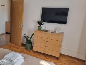 a bedroom with a dresser with a television on a wall at Apartament Tudor in Turda