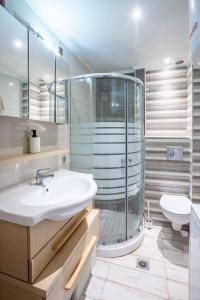 a bathroom with a shower and a sink and a toilet at Apartments Enastron 44 2 bedroom in Pefkochori