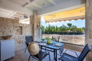 a dining room with a table and chairs and a large window at Apartments Enastron 44 2 bedroom in Pefkochori