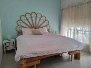 ein Bett mit einem großen Kopfteil in einem Schlafzimmer in der Unterkunft Seminyak Beach Tropical Hideaway Apartment in Seminyak