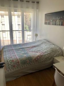 a bedroom with a bed and a large window at Nice flat St Germain en Laye centre 30 minutes to Paris in Saint-Germain-en-Laye
