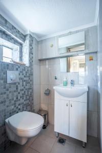a bathroom with a white sink and a toilet at Apartments Enastron 44 2 bedroom in Pefkochori +33 photos