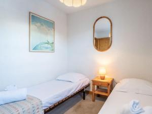 two beds in a room with a mirror and a table at Charmant appartement 4 pers au pied des pistes à Courchevel Le Praz - FR-1-568-49 in Courchevel