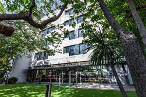 a building with a green lawn in front of it at Best Western Plus Hotel Alfa Aeropuerto in Barcelona