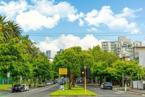 a traffic light on a city street with cars at Sora East Melbourne in Melbourne