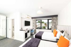 a hotel room with two beds and a television at Sora East Melbourne in Melbourne