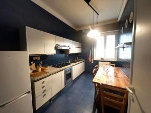 a kitchen with white cabinets and a wooden table at Casa ElleBi fronte spiaggia con posto auto gratuito in Pesaro