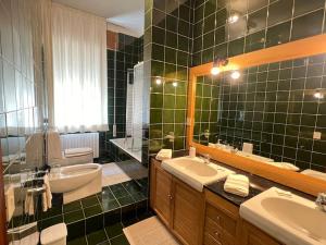 a green tiled bathroom with a sink and a toilet at Casa ElleBi fronte spiaggia con posto auto gratuito in Pesaro +20 photos