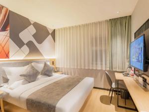 a hotel room with a bed and a desk and a television at Feifan Chengpin Hotel Beijing Tongzhou Orchard Global Resort Branch in Tongzhou