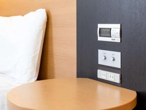 a table in a hotel room with a clock on the wall at Comfort Hotel Central International Airport in Tokoname