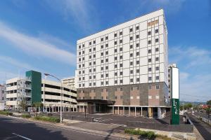 a large white building on the side of a street at Comfort Inn Kagoshima Taniyama in Kagoshima