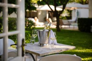 a table with wine glasses and a bucket of wine bottles at Grande Provence in Franschhoek