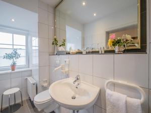 a white bathroom with a sink and a toilet at Posthotel Monegro in Steinfurt +24 photos