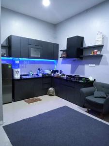a kitchen with black cabinets and a blue lighting at Villa Diva Sandik in Midang