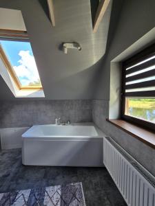 a white bath tub in a bathroom with a window at PUTNI Resort in Laukbeitini +67 photos