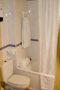 a bathroom with a toilet and a tub and a shower at Apartamentos Montreal in Sierra Nevada