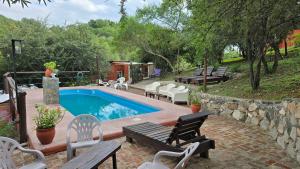 a swimming pool with chairs and a patio with a table at La Pasionaria in La Rancherita