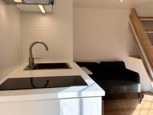 een keuken met een wastafel en een bank bij Studio Metro Paris La-defense in Asnières-sur-Seine
