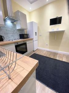a kitchen with white cabinets and a black rug at St James Residence close city centre in Killingbeck