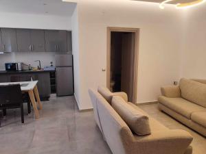 a living room with a couch and a table and a kitchen at Lena Studios in Sidari