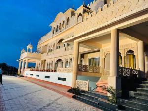 a large white building with stairs and balconies at Dhawala Resort By Aamod in Alwar