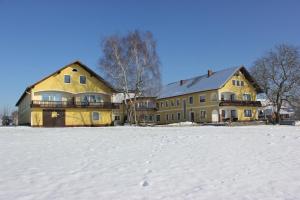 a large yellow building in a snow covered field at Windhör in Saxen