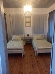 two beds in a room with wooden floors at Eresina in Eresos