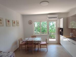 a kitchen and dining room with a table and chairs at Apartman Kora in Njivice