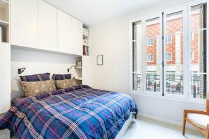 Un dormitorio blanco con una cama y una ventana. en GuestReady - Bright Apt near Sacré-Coeur, en París 5 fotos más