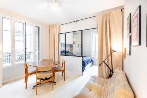 Un apartamento con una mesa de comedor y un dormitorio. en GuestReady - Bright Apt near Sacré-Coeur, en París