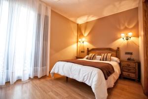 ein Schlafzimmer mit einem großen Bett und einem Fenster in der Unterkunft Hotel Santa Cruz in Cangas de Onís